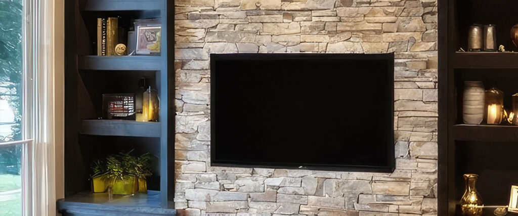 Flat screen TV professionally mounted on a stone brick fireplace wall with hidden wiring