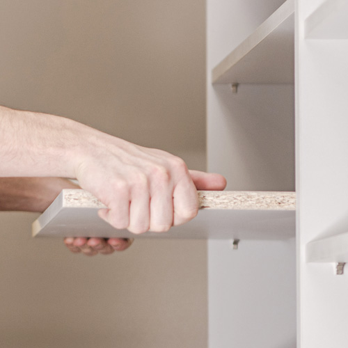 Hand assembling a cabinet shelf