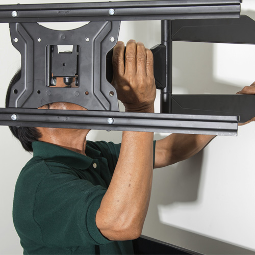 Technician securing wall mount bracket for flat-screen TV